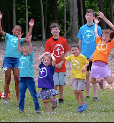kids waving wearing tanl shirts
